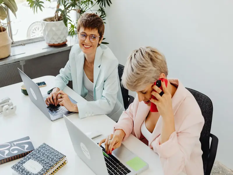 Two women at an office desk.
