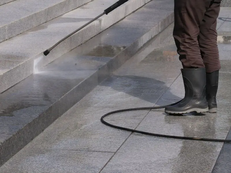 Pressure washing steps of a building.