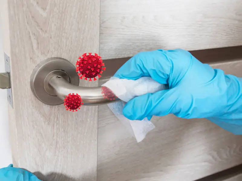 Cleaning door handle to get rid of germs.